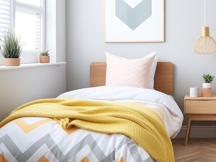 Brightly lit bedroom with a bed, table, and natural light coming through the windows.